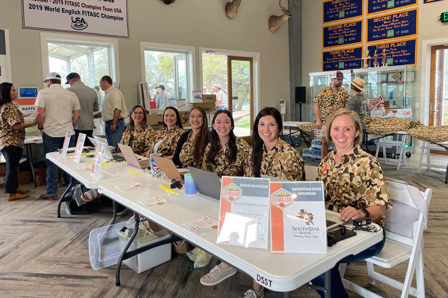 DSEF members smiling at table for Clays for Classroom event