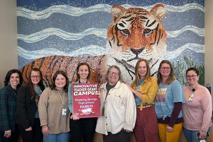 members of DSEF smiling in front of tiger mosaic